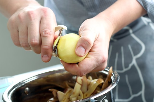 Man peeling potatoes. Kitchen working. Prepare food
