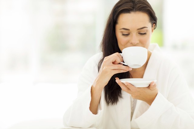 woman in bathrobe drinking coffee