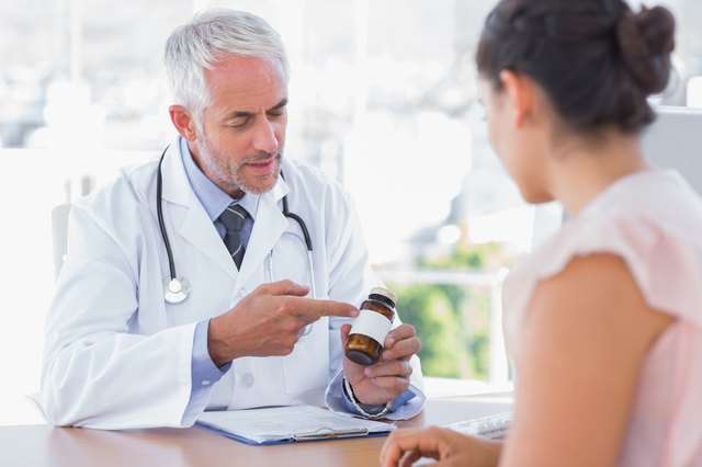 Doctor explaining the bottle of pills to patient