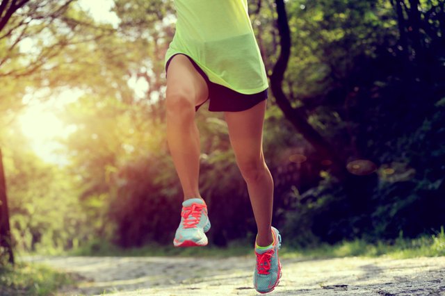 Runner athlete running on forest trail.