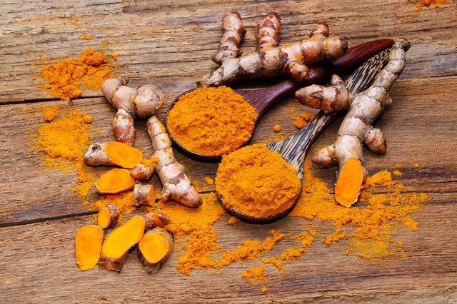 fresh turmeric roots on wooden table