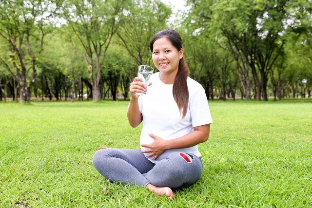 Pregnant woman with a glass of water in her hands