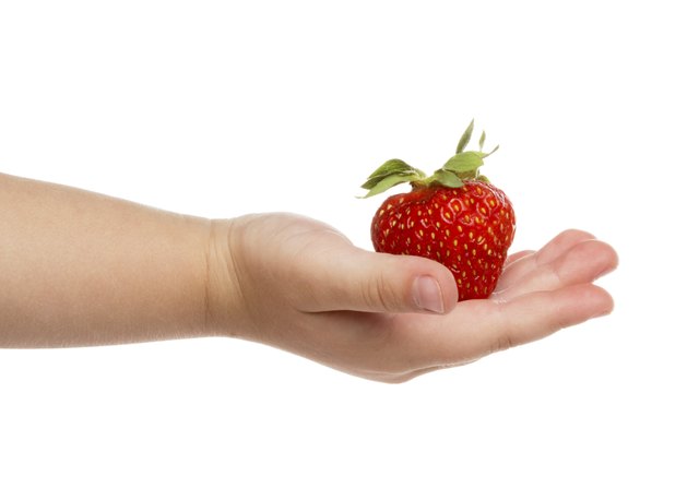 Child's hand with strawberries.