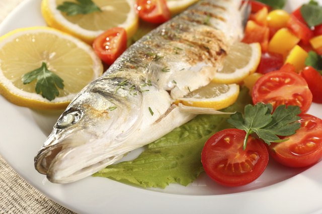 Delicious grilled fish on plate on table close-up