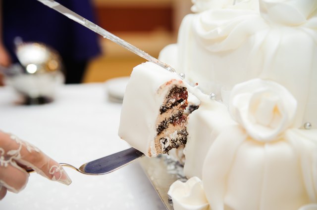 bride and groom are Slicing the wedding cake on reception