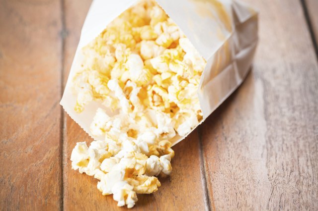 Popcorn paper bag opened with corn spilling out