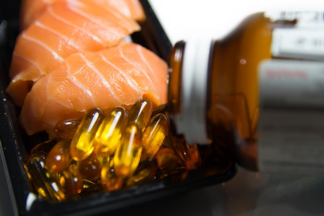 Fish oil with fish oil pills pored from container isolated