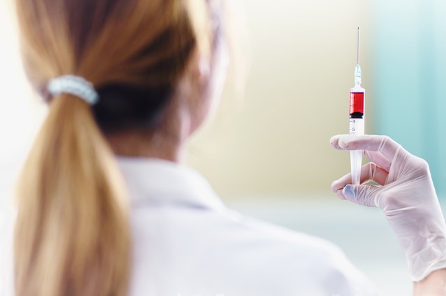 Doctor with red vaccine syringe in hand