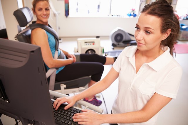 Female Patient Working With Physiotherapist In Hospital