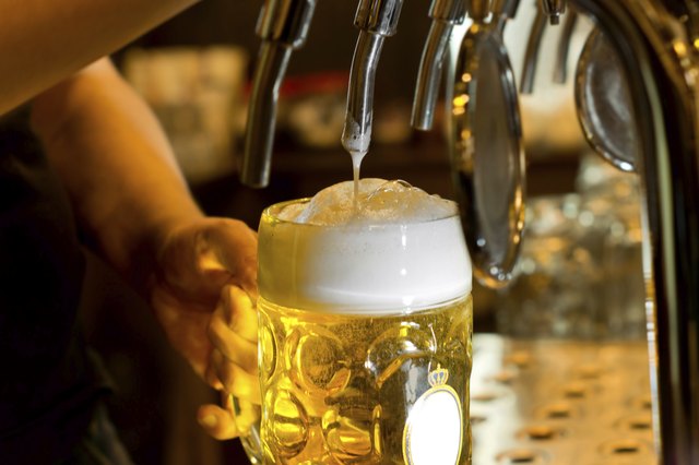 Man pouring a tankard of frothy beer