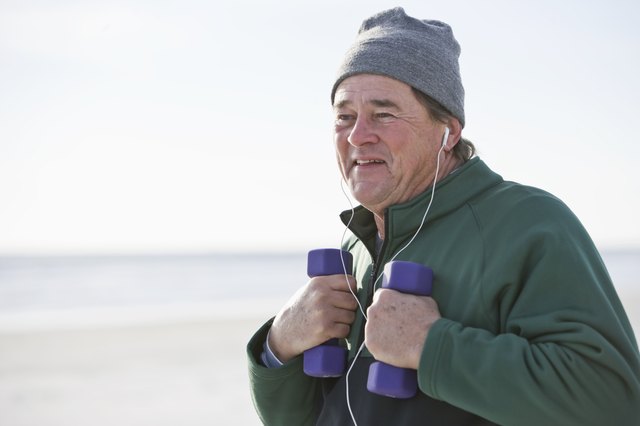 Senior man exercising with hand weights outdoors