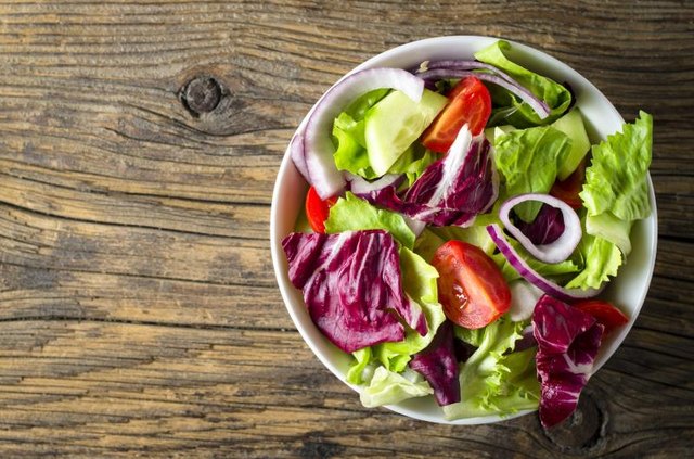 Fresh vegetables salad on wooden table. Top view