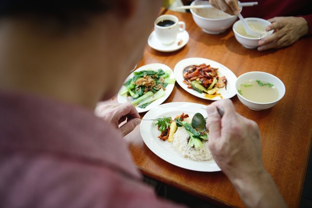 Over the shoulder shot of man eating his charsiew rice
