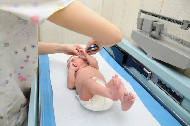 Healthy Newborn Infant on Pediatric Scale Examination Table