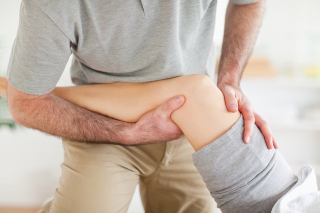 Chiropractor massaging a woman's knee