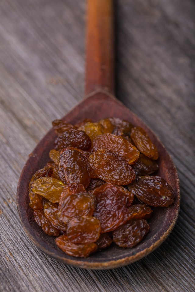 Raisins in a old wooden spoon