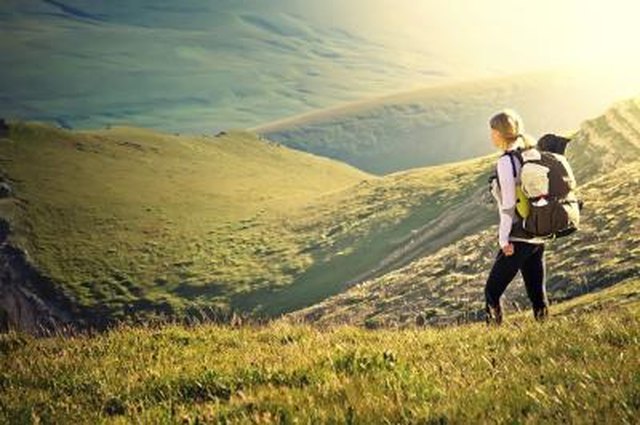 Woman Traveler with Backpack hiking in Mountains with beautiful summer landscape on background mountaineering sport lifestyle concept