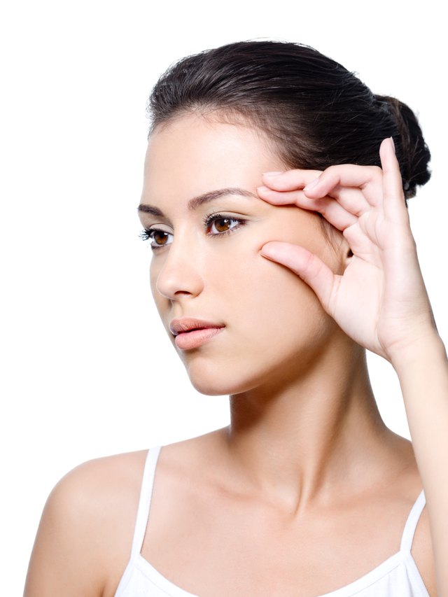 Woman pinching skin near her eye