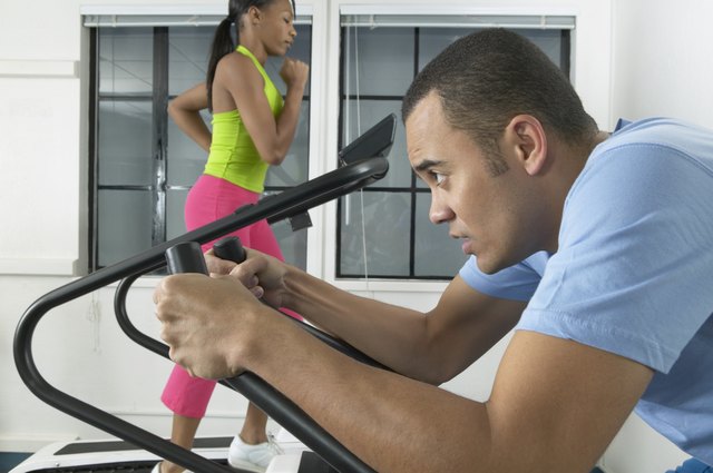 Young man and a young woman exercising on treadmills