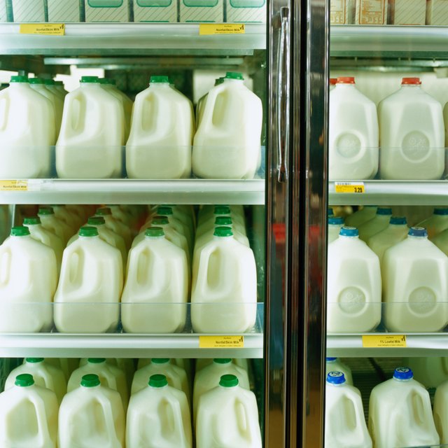 Cartons of milk in supermarket refrigerator, full frame