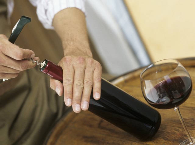Man opening bottle of wine,close-up of hands