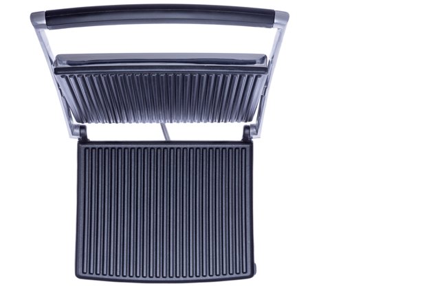 Open panini press showing the cast iron plates