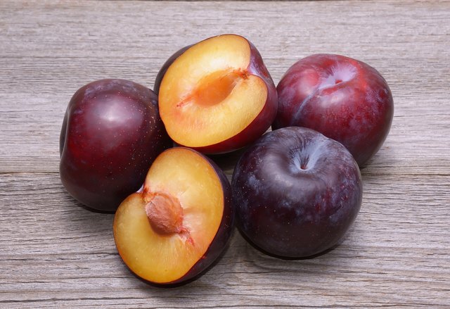 Fresh plums on wooden table