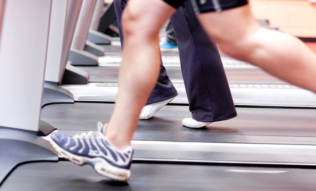Close-up of the legs of an athletic young woman exercising on a running machine