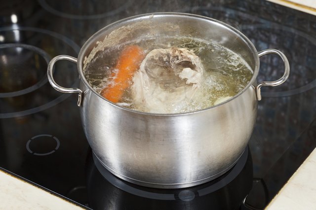 simmering chicken soup with seasoning vegetables