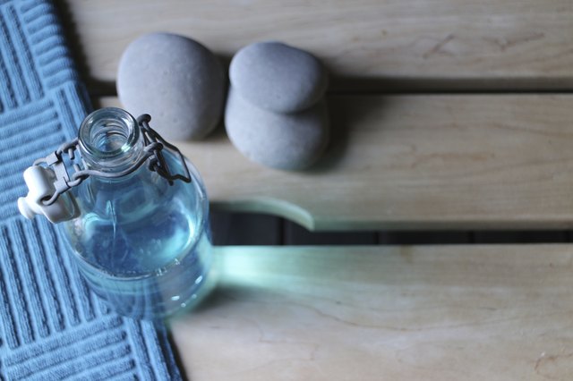Bottle of blue liquid soap and spa stones