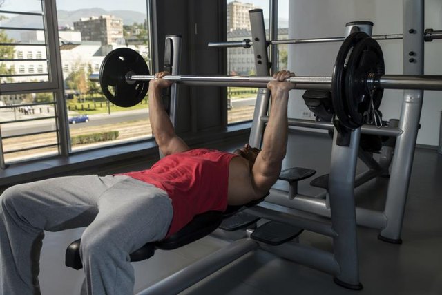 Young Men In Gym Exercising On The Bench Press