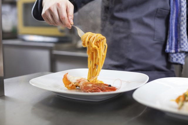 Chef plating up seafood pasta