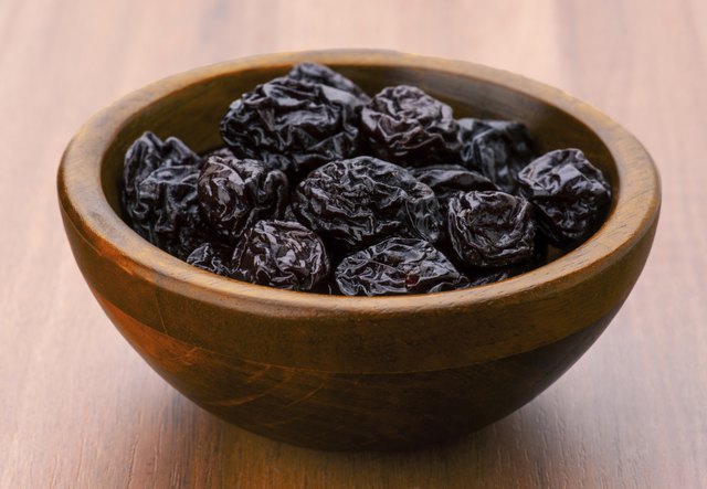 lot of prunes in transparent glass bowl