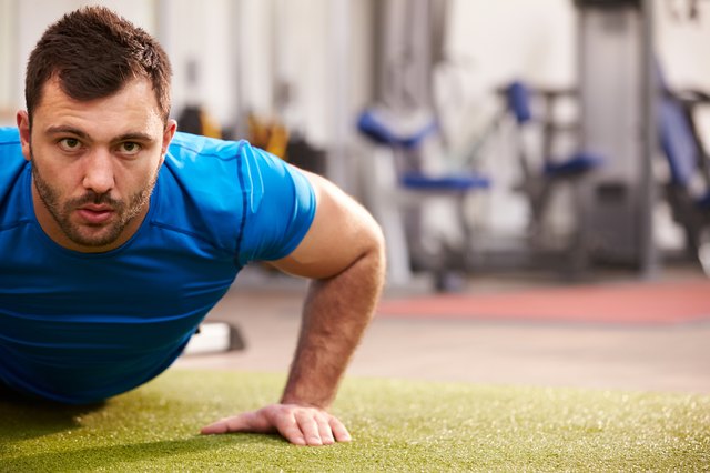 Young man doing push ups at a gym