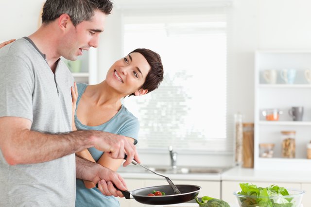 Woman smiling at her pan-holding husband