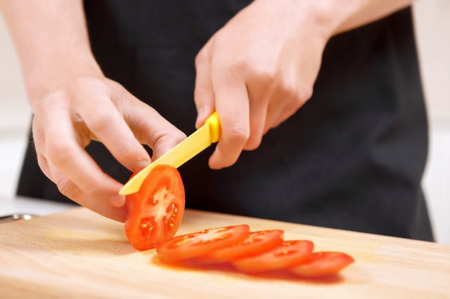 Close up of man slicing tomatoes