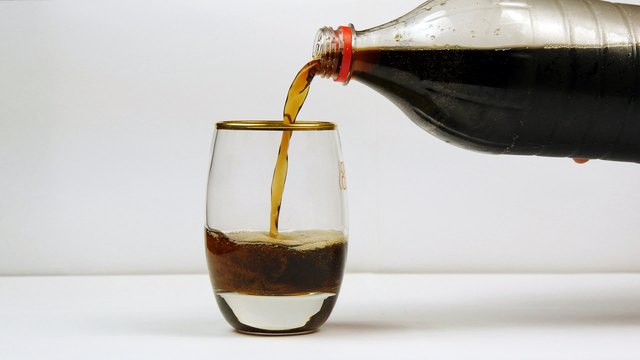 Pouring soda from the bottle into a glass