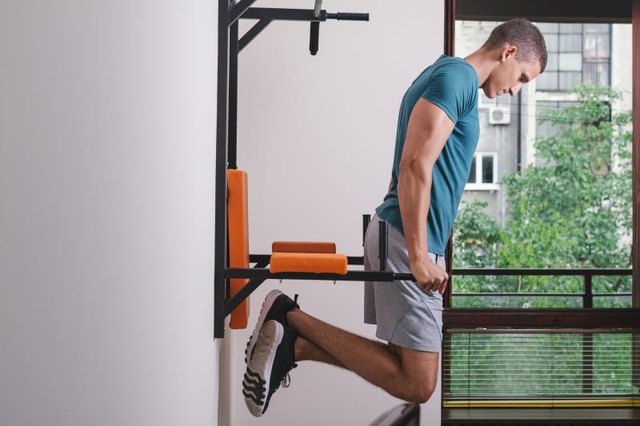Muscular man working out in front of window