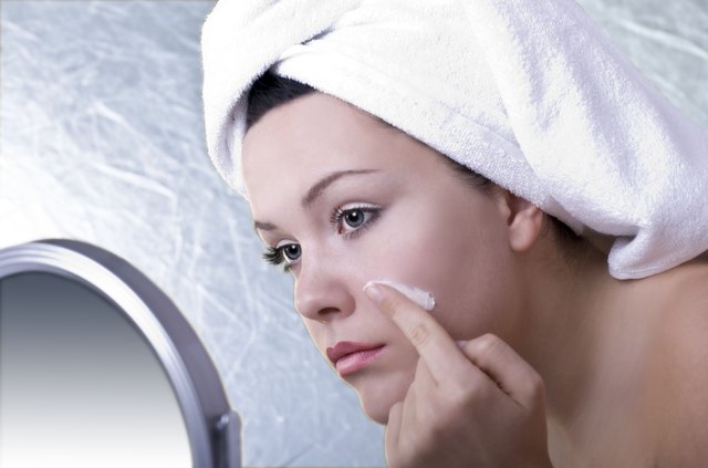 Spa girl putting cream on her face