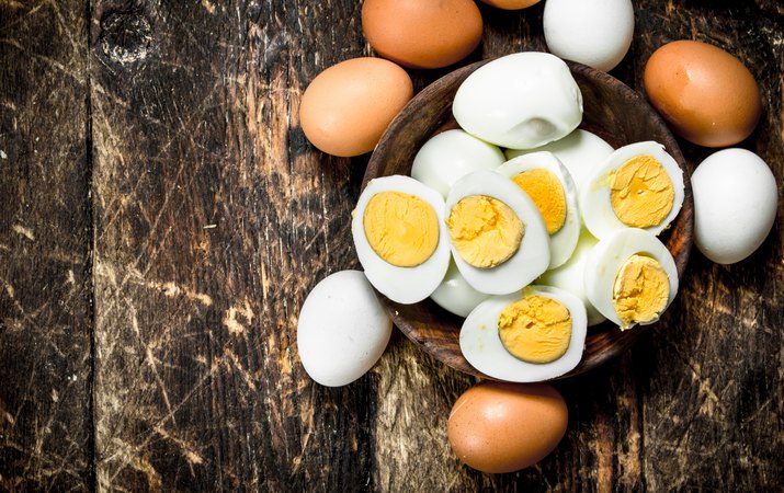 Hard-boiled eggs in a bowl on a wooden table