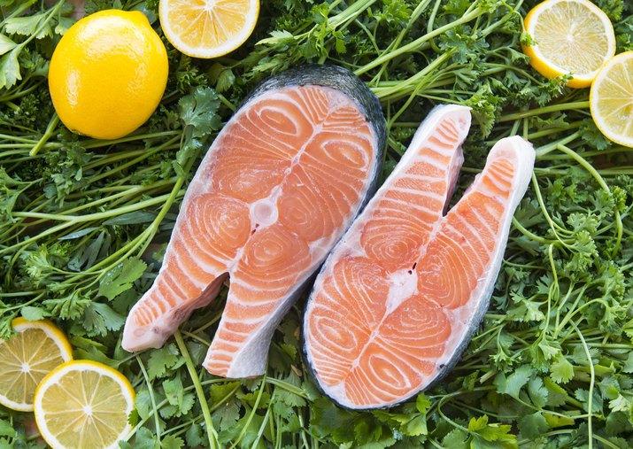 Salmon steaks on greens with lemons