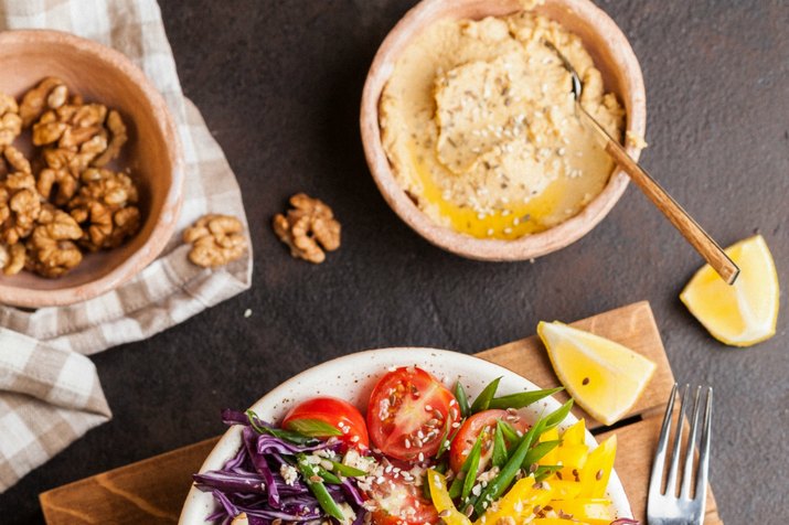 Hummus, tomatoes and walnuts on table