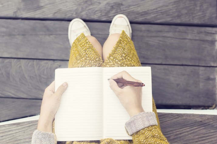 Woman writing in a blank journal