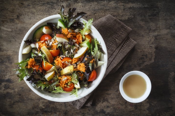 Fresh mixed salad with kohlrabi, tomato and cucumber on wood