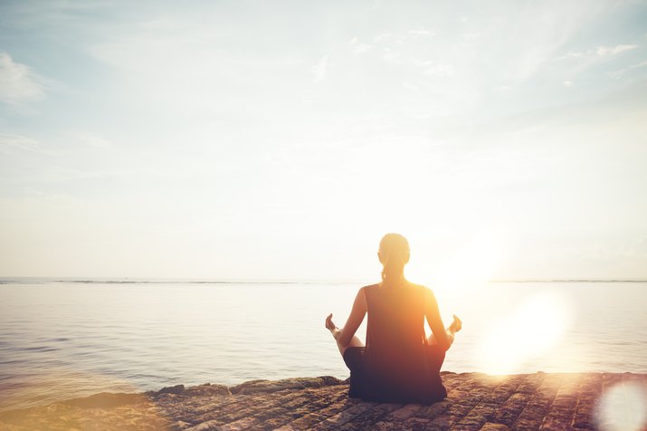 Woman on beach practicing yoga