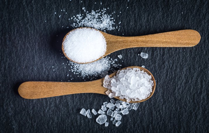 Different types of salt. Top view on two wooden spoons