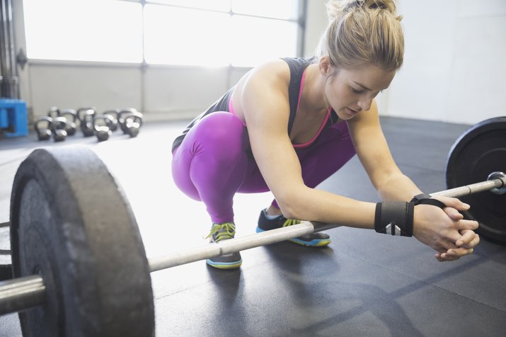Woman leaning on barbell