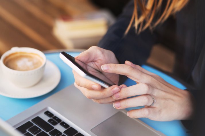 Woman typing in phone at work