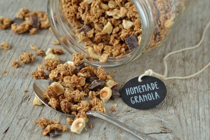 Close-Up Of Homemade Granola By Glass Jar And Tag With Text On Wooden Table