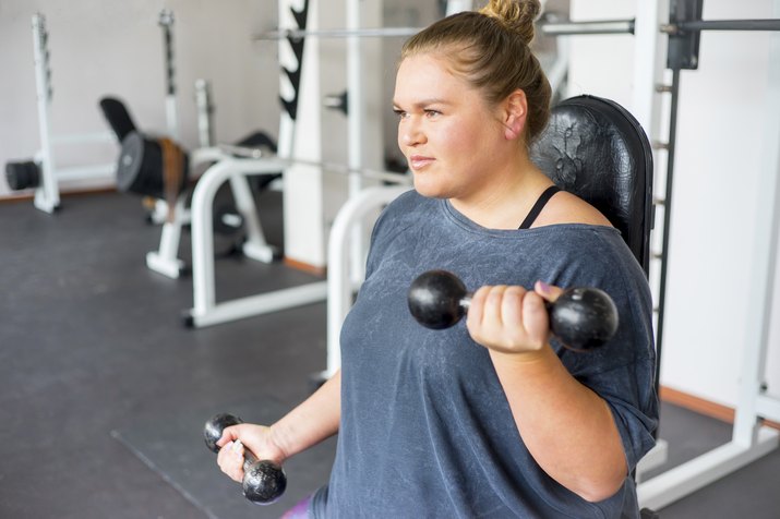 Woman doing arm workout l in a gym